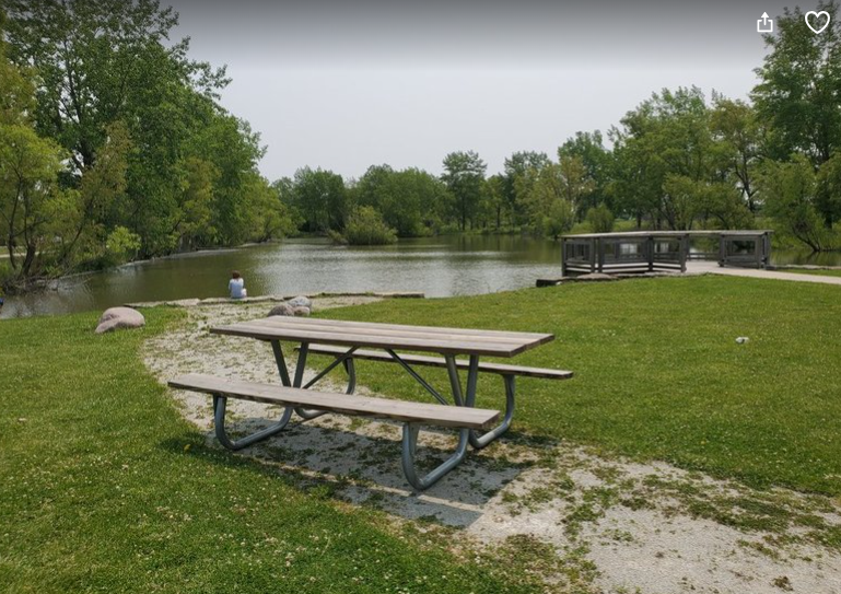 Person sitting and enjoying the view next to a fishing dock at Willowhaven Park in Kankakee, Illinois.