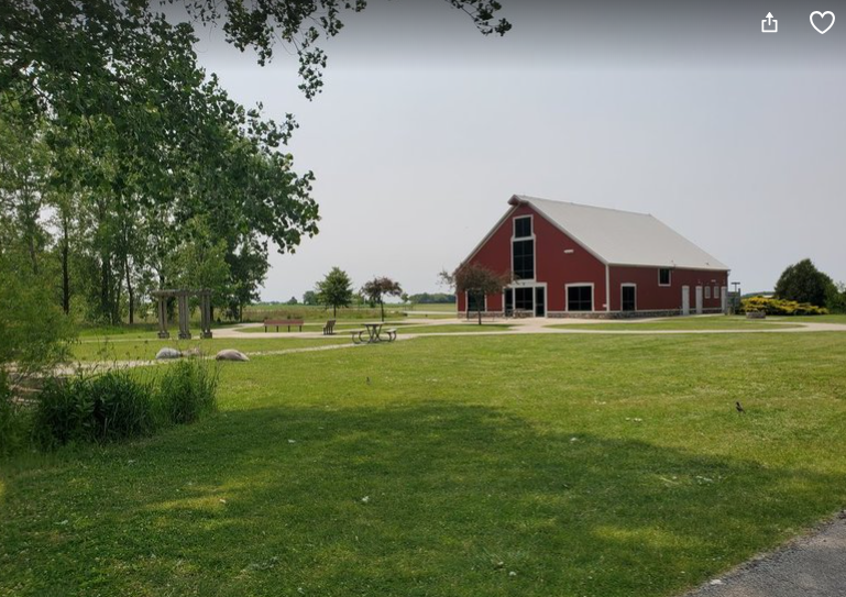 Wide shot of the green space, trail, and barn at WIllowhaven Park in Kankakee County.